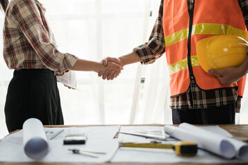 Fototapeta premium Close-up image of an engineer shaking hands with his coworker during the meeting. teamwork, building trust, unity
