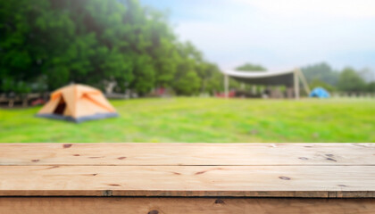 Wooden table top on blur tent camping travel tent and grass field. Fresh and Relax concept. For...