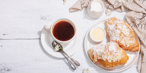 Good morning concept. Breakfast with cup of coffee and fresh croissant. Sweet creamy sauce