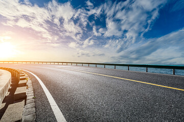 Asphalt road and sky clouds at sunset