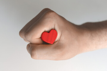 Fototapeta premium Wooden red heart clenched in hand
