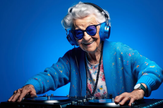 Happy Elderly Woman Plays Music on a DJ console, blue background