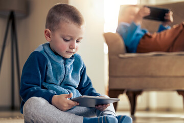 Cute little kid playing games on smartphone