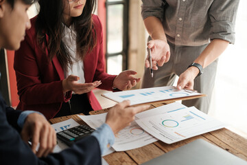Close up group of business men and woman discussion and brainstorming, bookkeeping audit graph and chart documents at desk, teamwork concept.