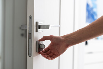 Man changing the door lock at home