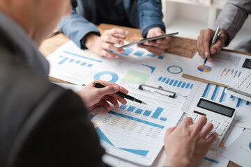 Close up group of business men and woman discussion and brainstorming, bookkeeping audit graph and chart documents at desk, teamwork concept.