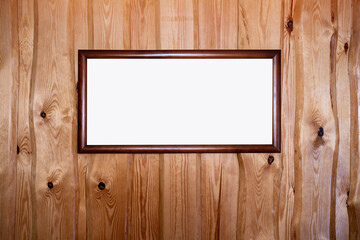 Empty white wooden frame hanging on wooden wall in cottage house inside. Art decoration and mockup...
