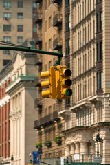 Traffic light signal in the city. American style yellow traffic light in New York City. Traffic in the city. Background with classical buildings.