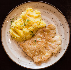 Appetizing chicken breasts in batter with mashed potatoes on plate