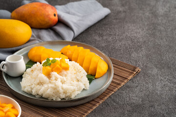 Delicious Thai mango sticky rice with cut fresh mango fruit in a plate.