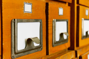 Close-up of a wooden old vintage shelf of file cabinets in a library. Sorting, organizing, knowledge