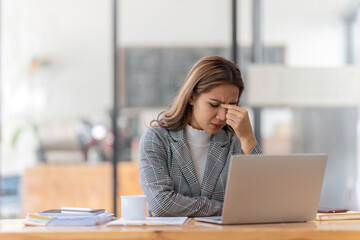 Fototapeta na wymiar Woman working at with headache, burnout and stress over social media marketing or company deadline. Anxiety, exhausted and tired web or online business advertising expert with migraine