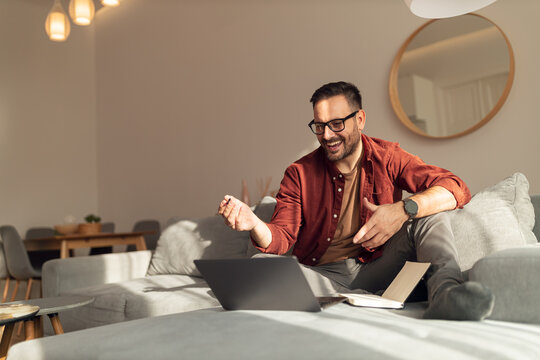 Positive, happy man talking to someone, over the laptop, explaining something. - Powered by Adobe