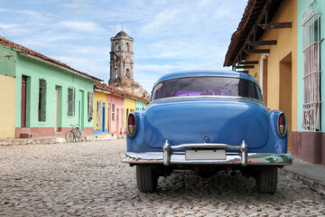 Old car inside a colorful Cuban Town of Trinidad with no people 