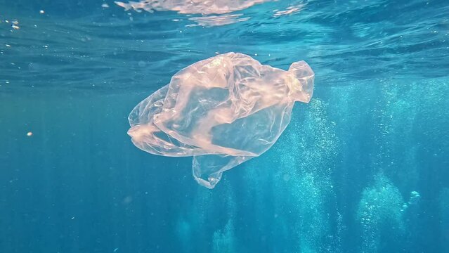 Piece of plastic bag floating in the sea. Danger of free-floating waste to animals.
