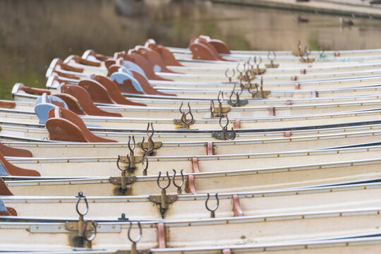 A row of identical row boats lined up at a dock
