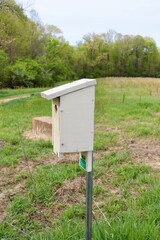 A close view of the old wood birdhouse in the field.