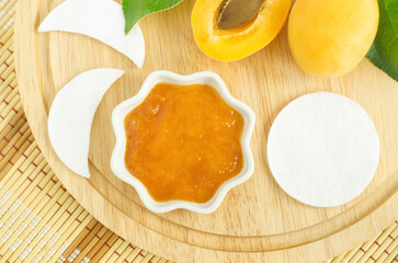 Apricot mask (scrub) in a small white bowl. Homemade face or hair mask, natural beauty treatment and spa recipe. Copy space.
