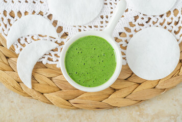 Homemade green tea matcha (kelp, algae, spirulina) face or hair mask (scrub) in a small white bowl....