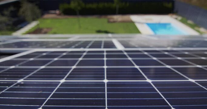 Slider shot: Solar panels on the roof of the house, below you can see the pool and green lawn.