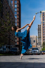 Fototapeta na wymiar Beautiful Asian ballerina dancing outdoors. Urban landscape.