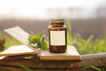 Glass container holding natural pills, medicine. Empty label, book and medical bottles.