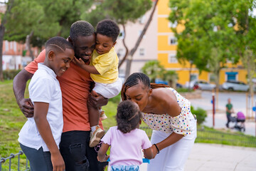 African black ethnicity family having fun with happy children together in city park