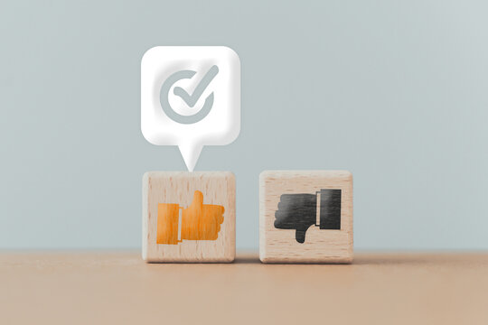 Thumb up and down icon on wooden cube block with approval sign on white speech bubble , like or dislike , approve or reject, voting, evaluation, score concept