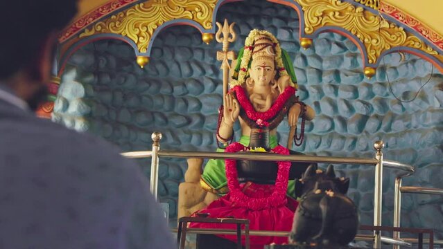 A view of a man praying before Lord Shiva, expressing devotion and reverence