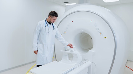 A male doctor sets up an MRI machine before receiving a patient. Setting up professional equipment in the clinic.