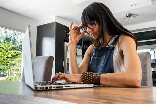 Business Woman Working From Home While Looking At Laptop. Confident Woman Using Laptop.