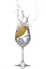 Slice of lemon inside water creating a splash against white background. 
