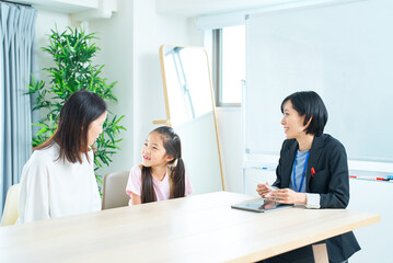Fototapeta premium 親子とスーツ姿の女性の会話シーン
