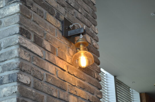 One modern lamp on the brick wall, white ceiling, cozy cleam interior