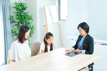 Fototapeta premium 親子とスーツ姿の女性の会話シーン