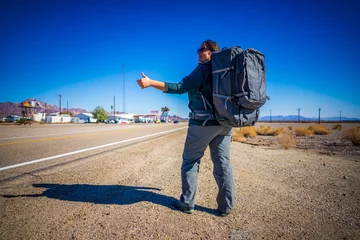 Gordijnen Hitchhiking Woman with Travel Backpack on Route 66 © feel4nature