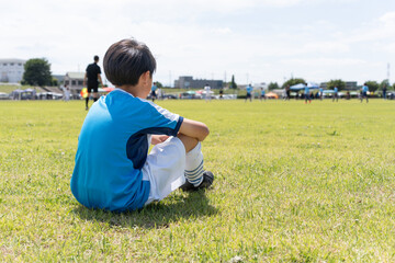 サッカーの試合を見ているアジア人の子供