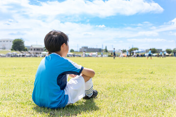 サッカーの試合を見ているアジア人の子供