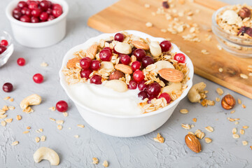 Healthy breakfast food with granola, yogurt, fruits and nuts. Dessert parfait with dried fruits for breakfast