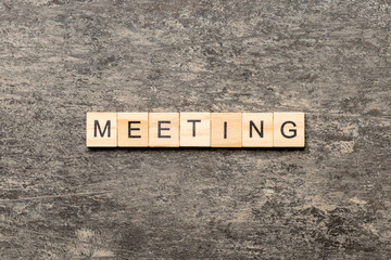 MEETING word written on wood block. MEETING text on cement table for your desing, concept