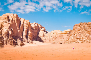 Female tourist solo hike explore travel trekking in Wadi Rum Desert, Jordan. Beautiful rock formations in Wadi-Rum desert, Jordan, Middle East