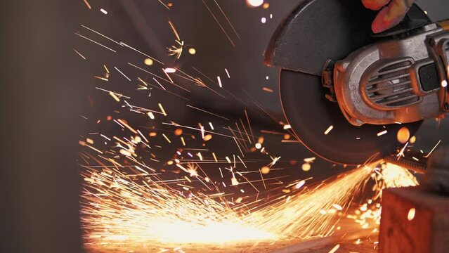 Metal is cut with a grinder, sparks fly.