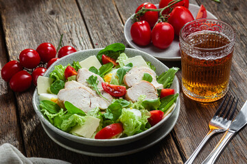 Salad of chicken fillet, eggs, tomatoes and cheese in a plate. Caesar salad