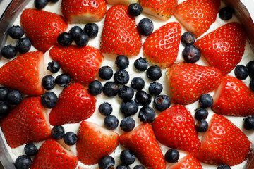 Round cream cake with berries, blueberries, strawberries, top view close up background.