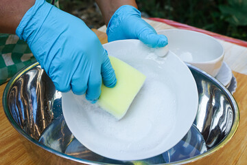 Hands use sponge scrubber to clean dish. Concept, daily chore, household cleaning kitchen utensils....