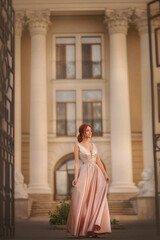 Fototapeta premium Beautiful slender girl in an evening dress. Prom. Graduate. Schoolgirl. Student. Girl with long red hair. Portrait of a girl. Girl dancing. Tenderness. Fashionable girl.