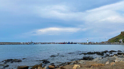 Kalekoy lighthouse and beach view at sunset of Gokceada Imbros island kalekoy harbor. Canakkale, Turkey