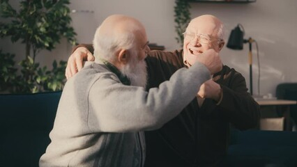 Two happy elderly best friends bumping fists, male friendship, trust, care
