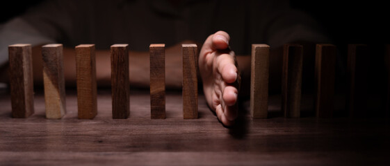 insurance with hands protect domino. Businessman hands stop dominoes falling in business crisis....