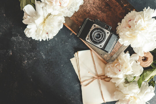 Summer background, flat lay layout, peonies and retro camera